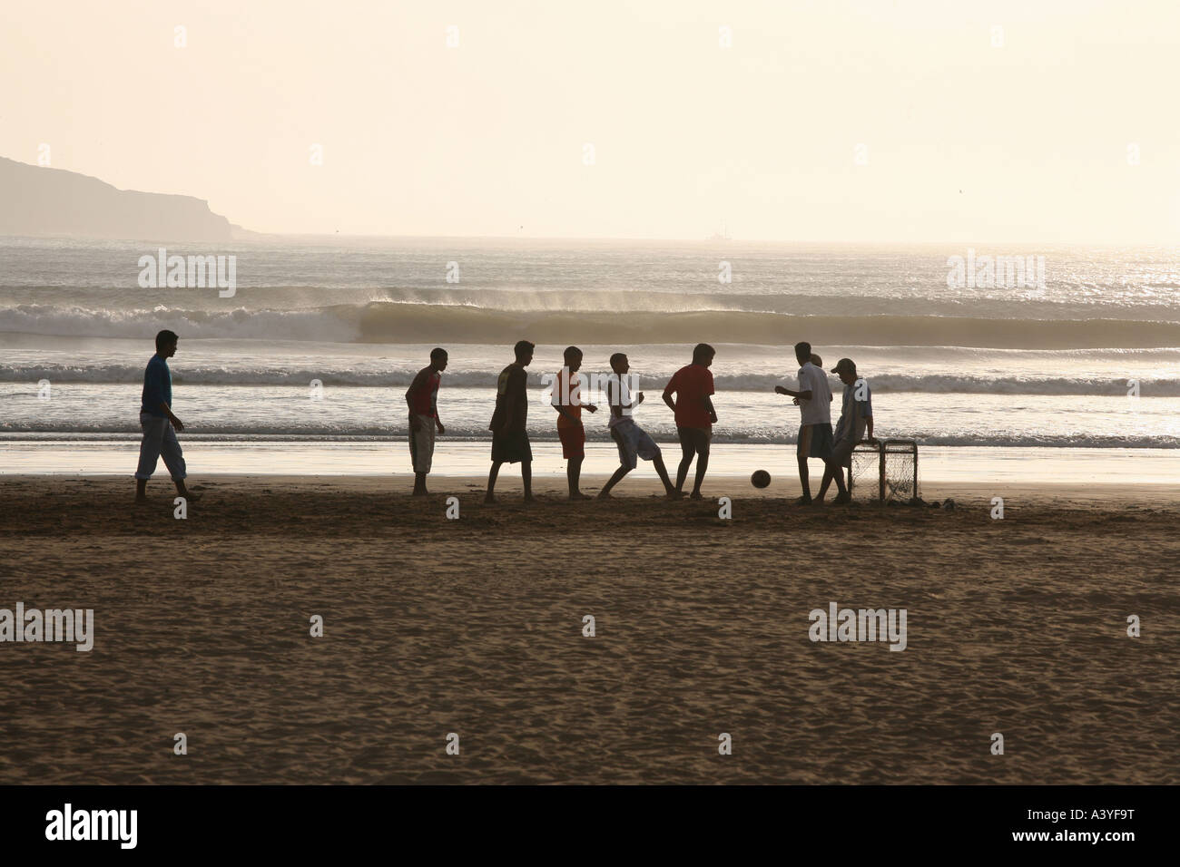 Ragazzi che giocava a calcio sulla spiaggia Foto Stock