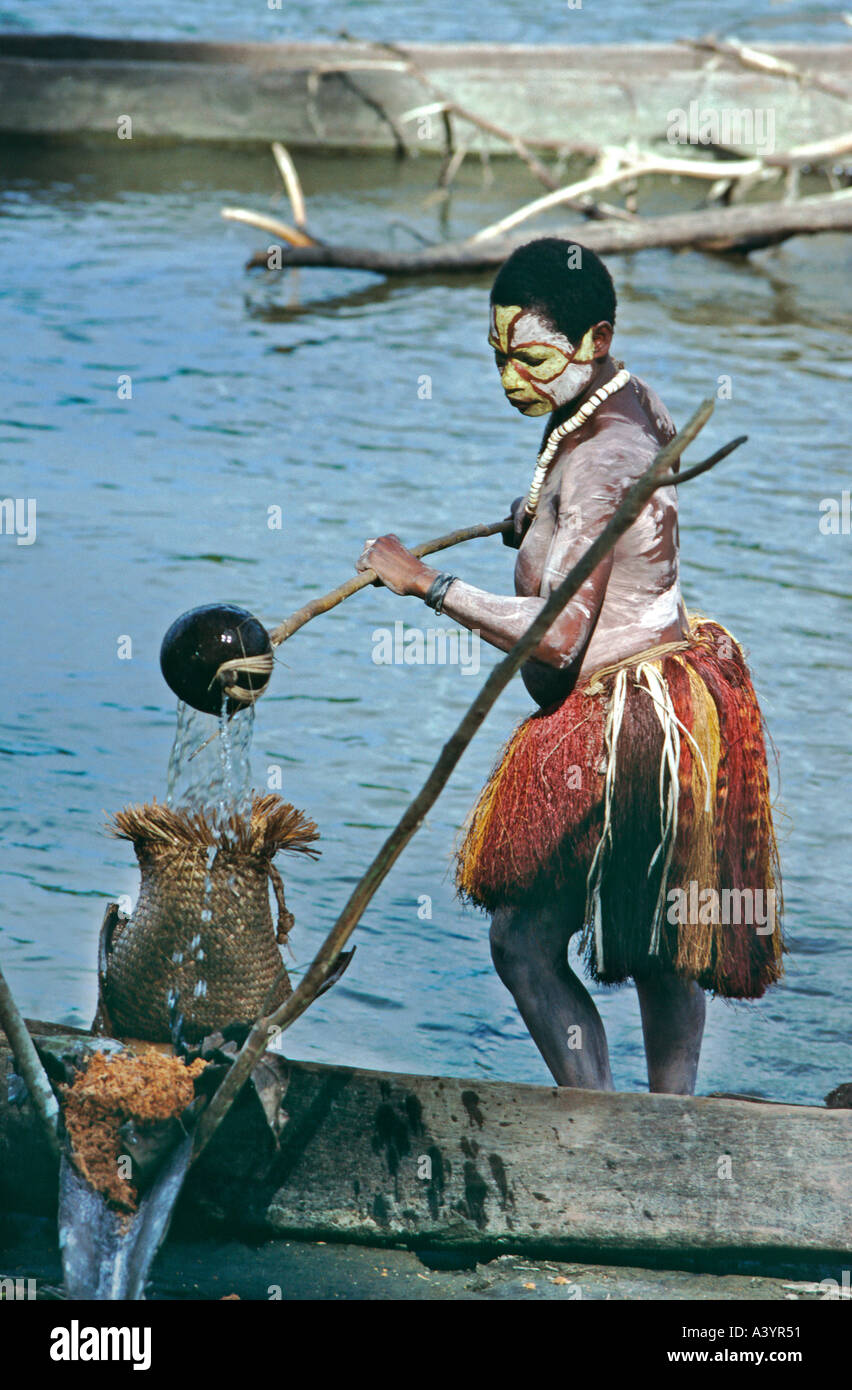 Donna in erba lavaggio gonna sago sulla banca del fiume del fiume Karawari in alto Sepik regione di Papua Nuova Guinea Foto Stock