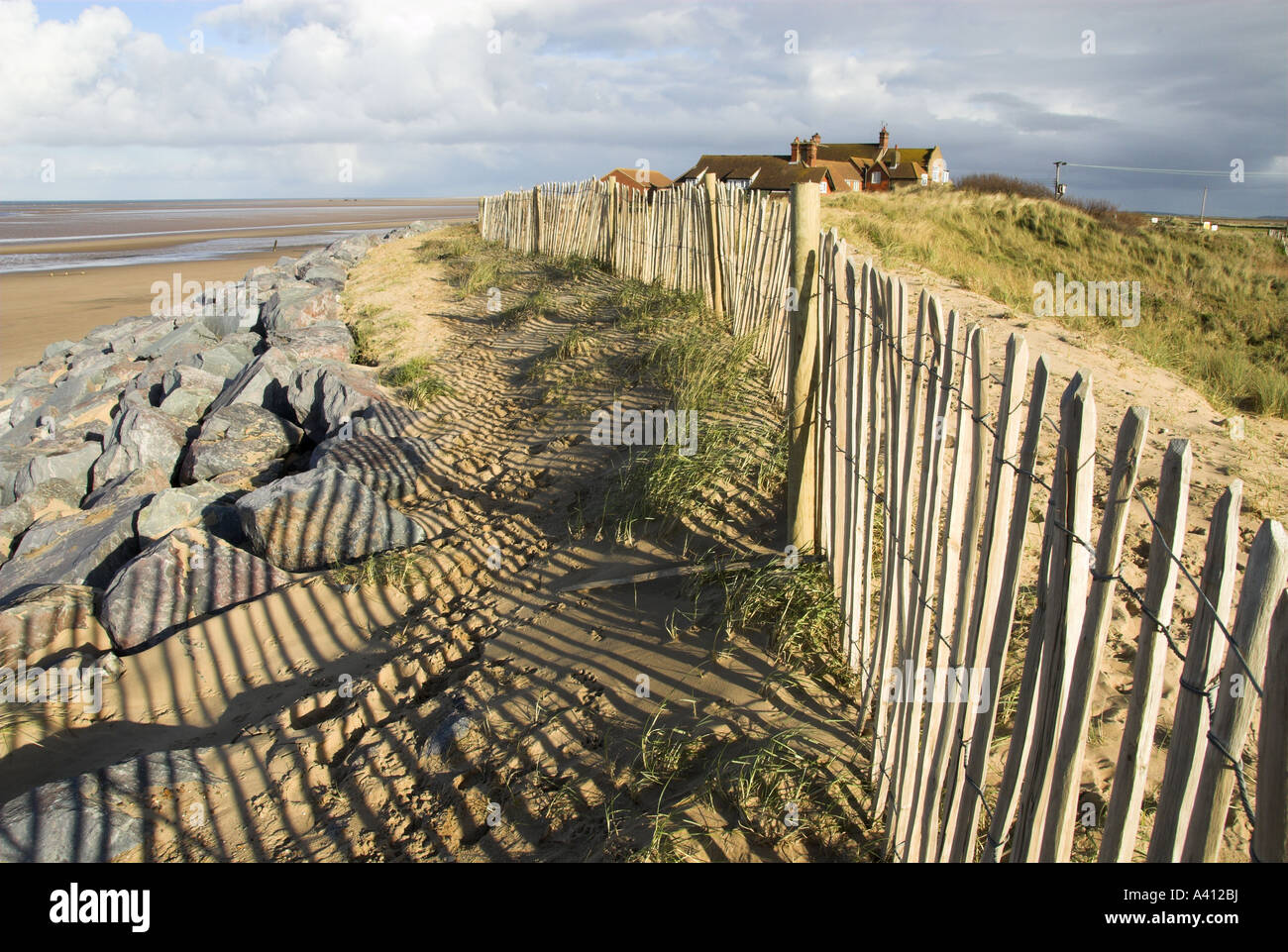 Scherma di castagno e masso di granito proteggere le dune costiere e gli edifici NORFOLK REGNO UNITO Foto Stock