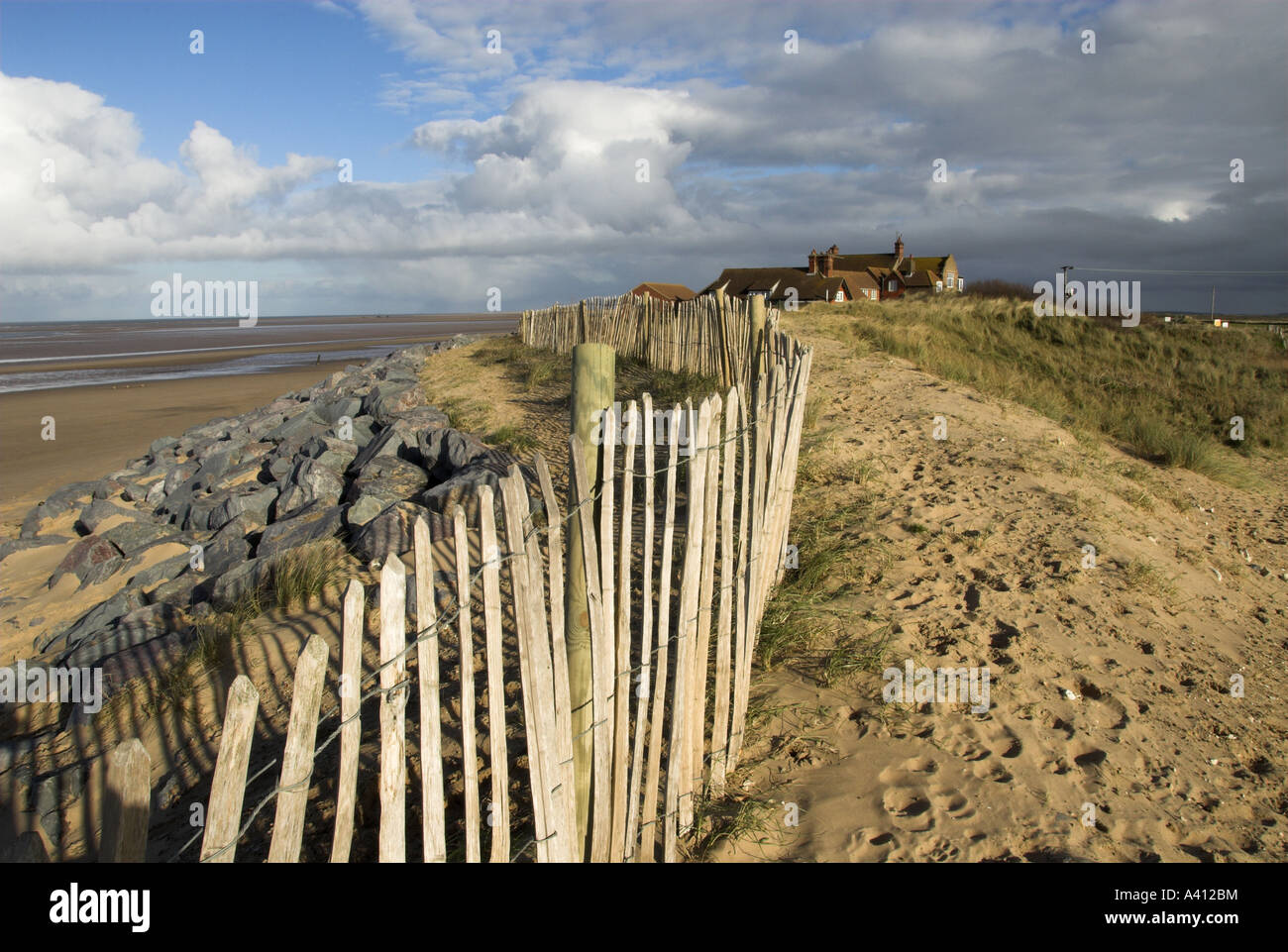 Scherma di castagno e masso di granito proteggere le dune costiere e gli edifici NORFOLK REGNO UNITO Foto Stock