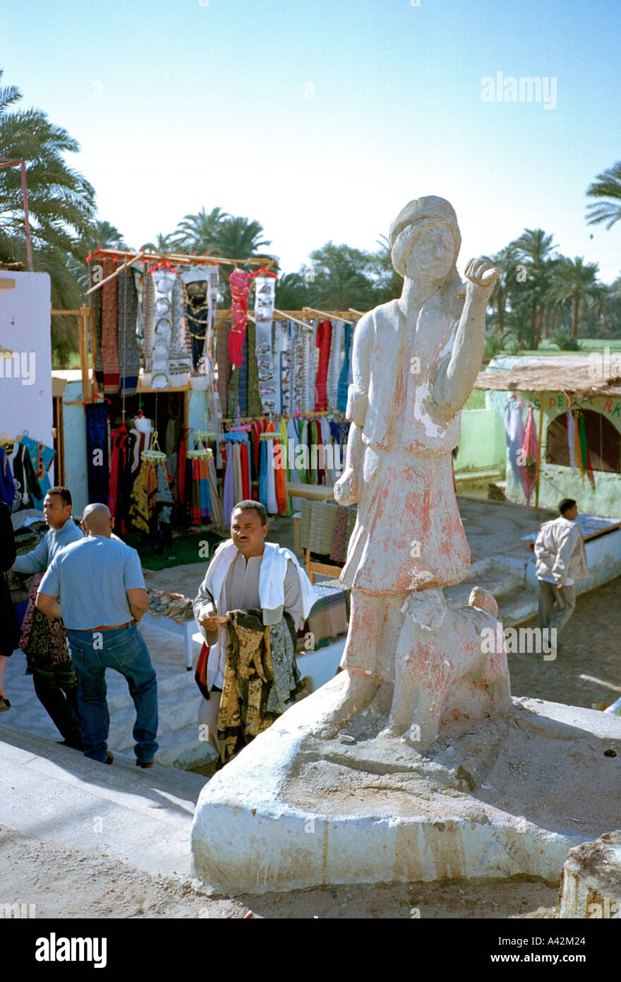 Un mercato stradale sulla strada da Luxor ad Assuan in Egitto vanta una scultura primitiva Foto Stock