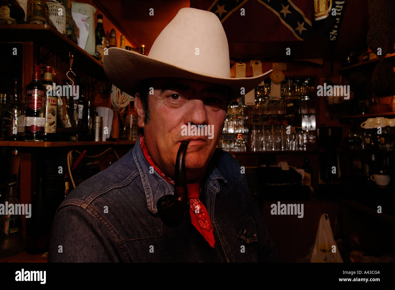 Un uomo israeliano che indossa un cappello da cowboy che fuma un tubo  dentro Un bar