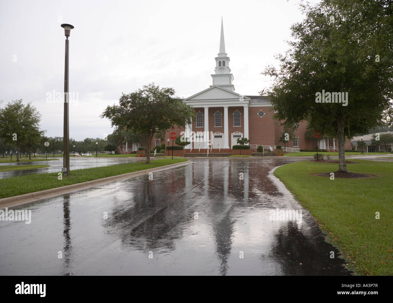 Chiesa riflessa in wet carraio durante la pioggia Foto Stock