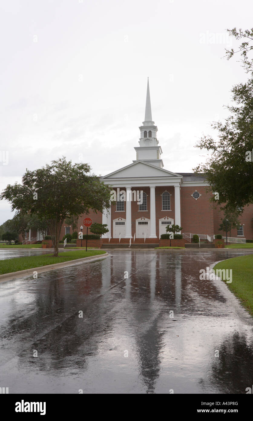 Chiesa riflessa in wet carraio durante la pioggia Foto Stock