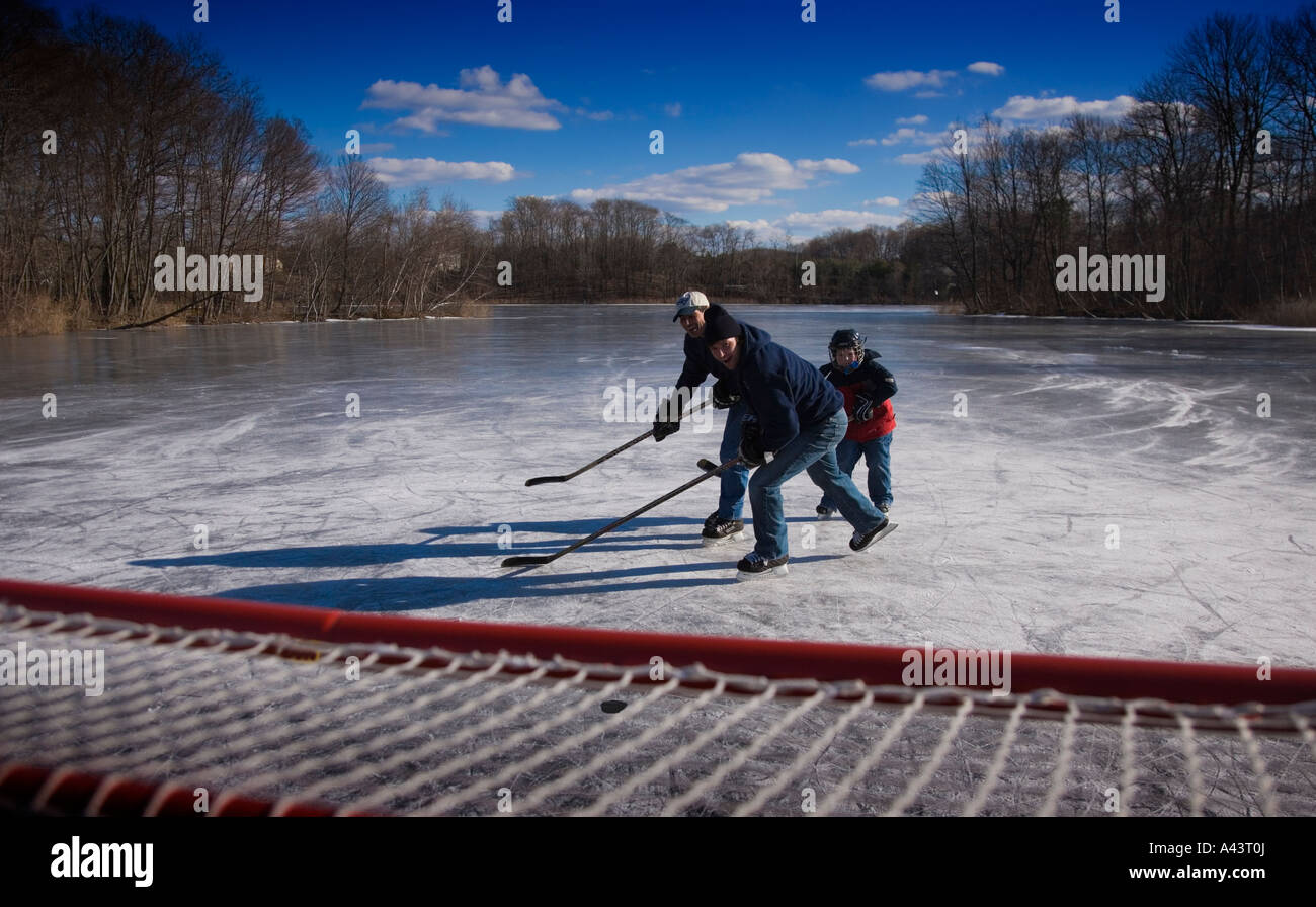 Riproduzione di hockey su ghiaccio su un laghetto congelato Foto Stock