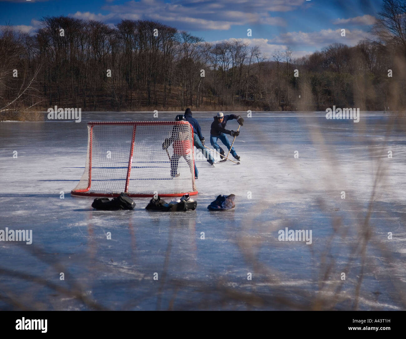 Ragazzi giocare hockey su ghiaccio su un laghetto congelato Foto Stock