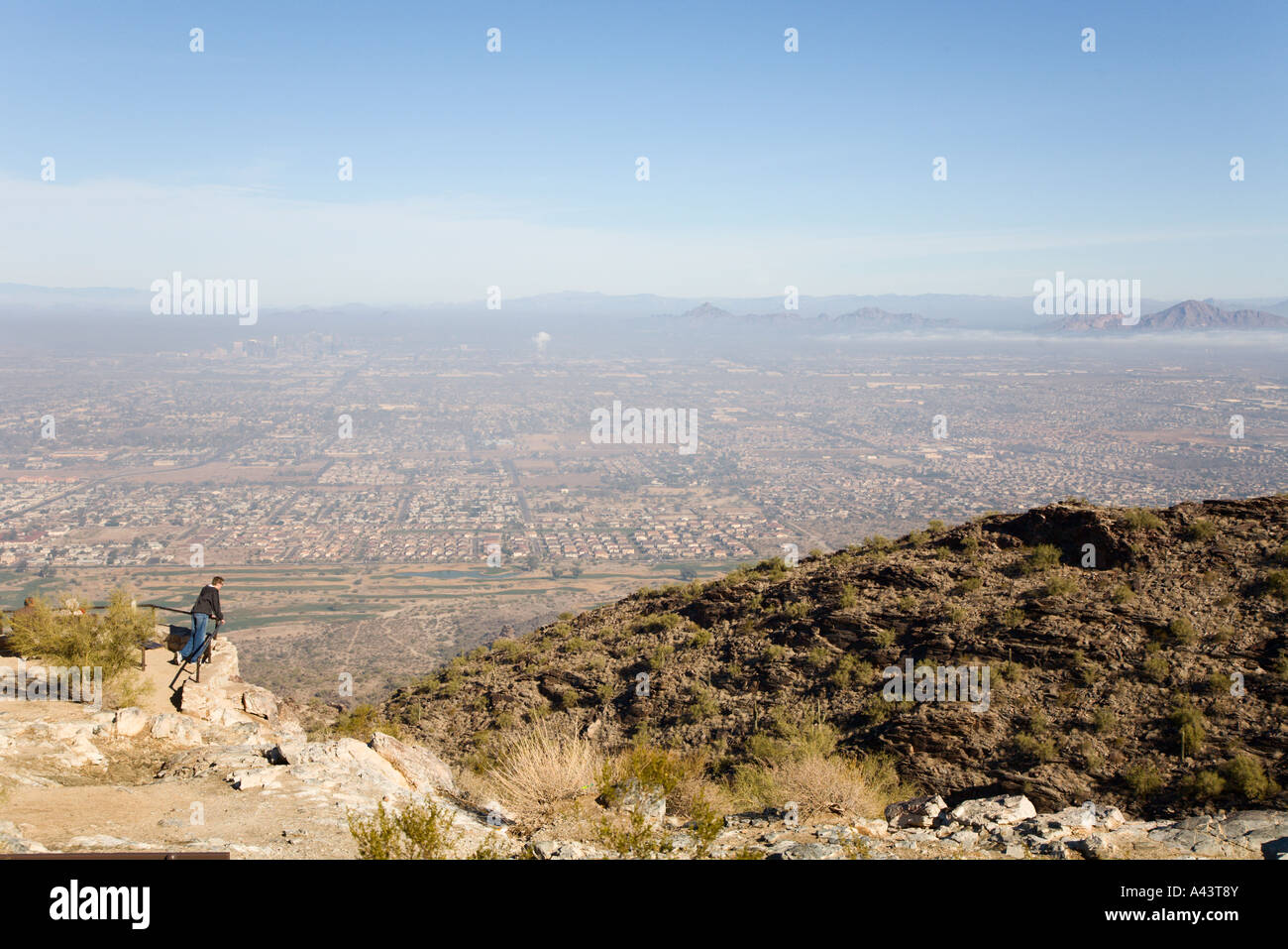 Ragazzo adolescente guardando giù alla città di Phoenix, Arizona da scenic si affacciano su South Mountain Foto Stock