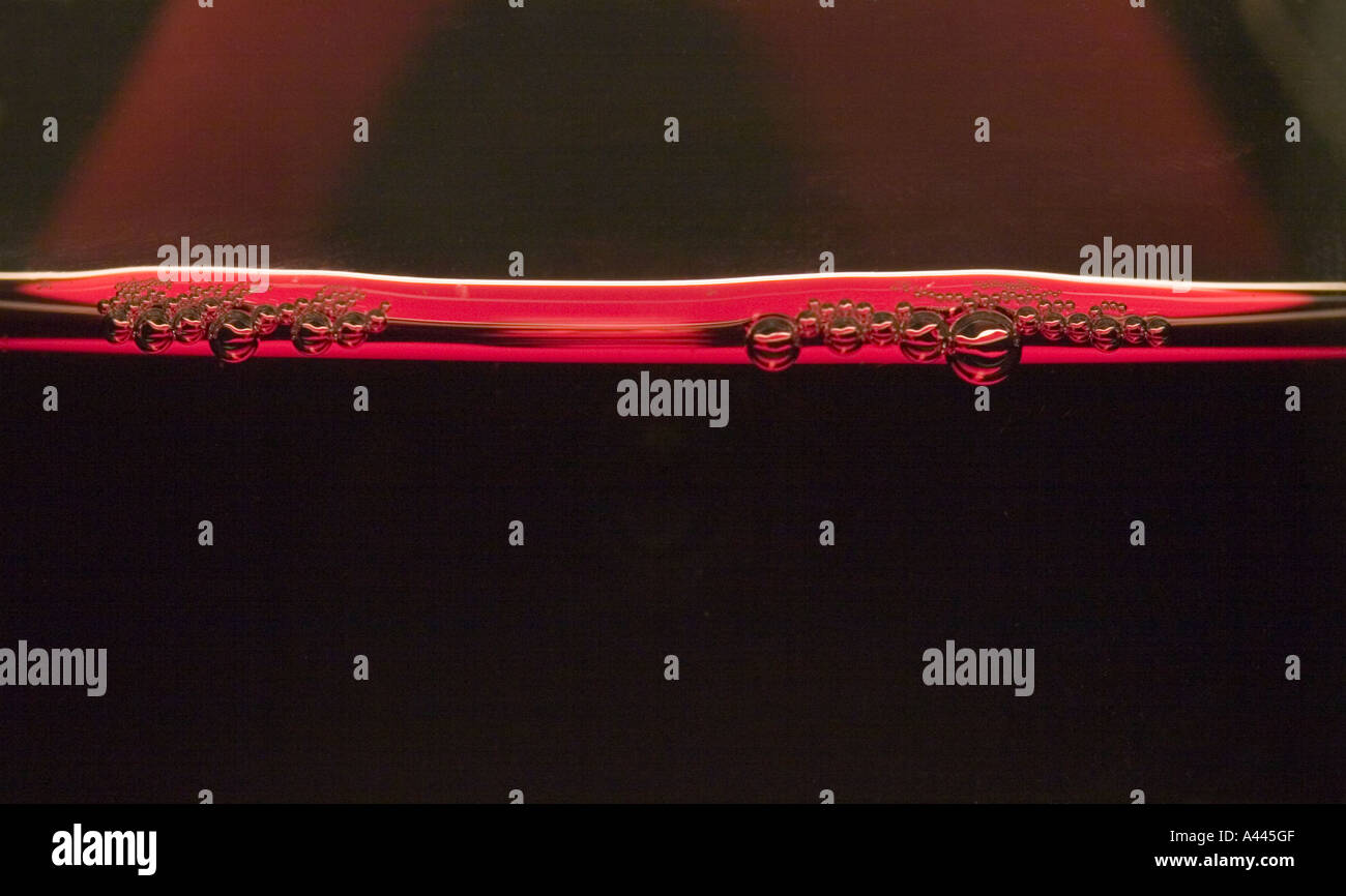 Close up dettaglio di bolle in un bicchiere di vino rosso Foto Stock