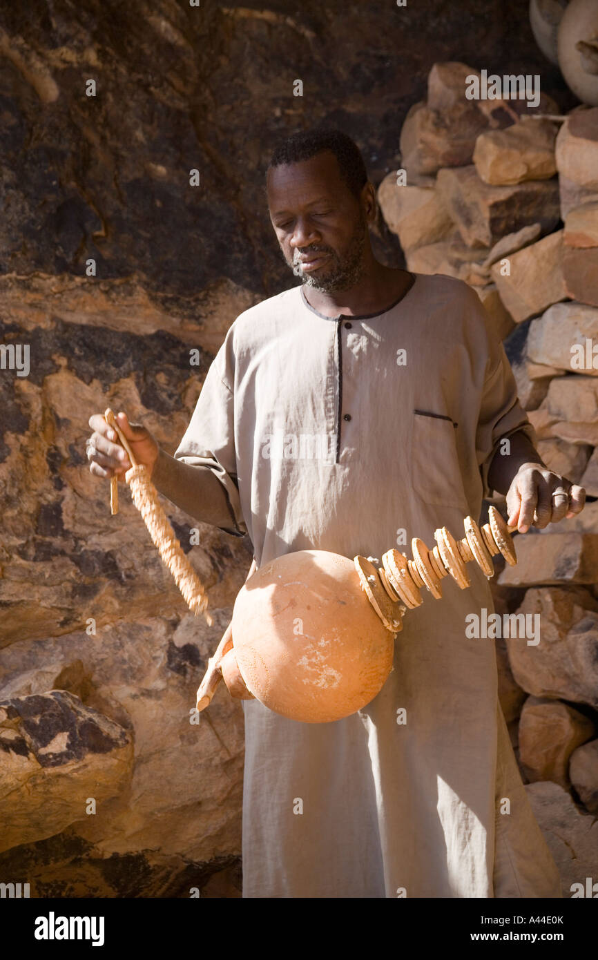 Uomo che mostra lo strumento musicale presso il punto in cui la circoncisione riti svolgerà,Songo, Mali, Africa occidentale Foto Stock
