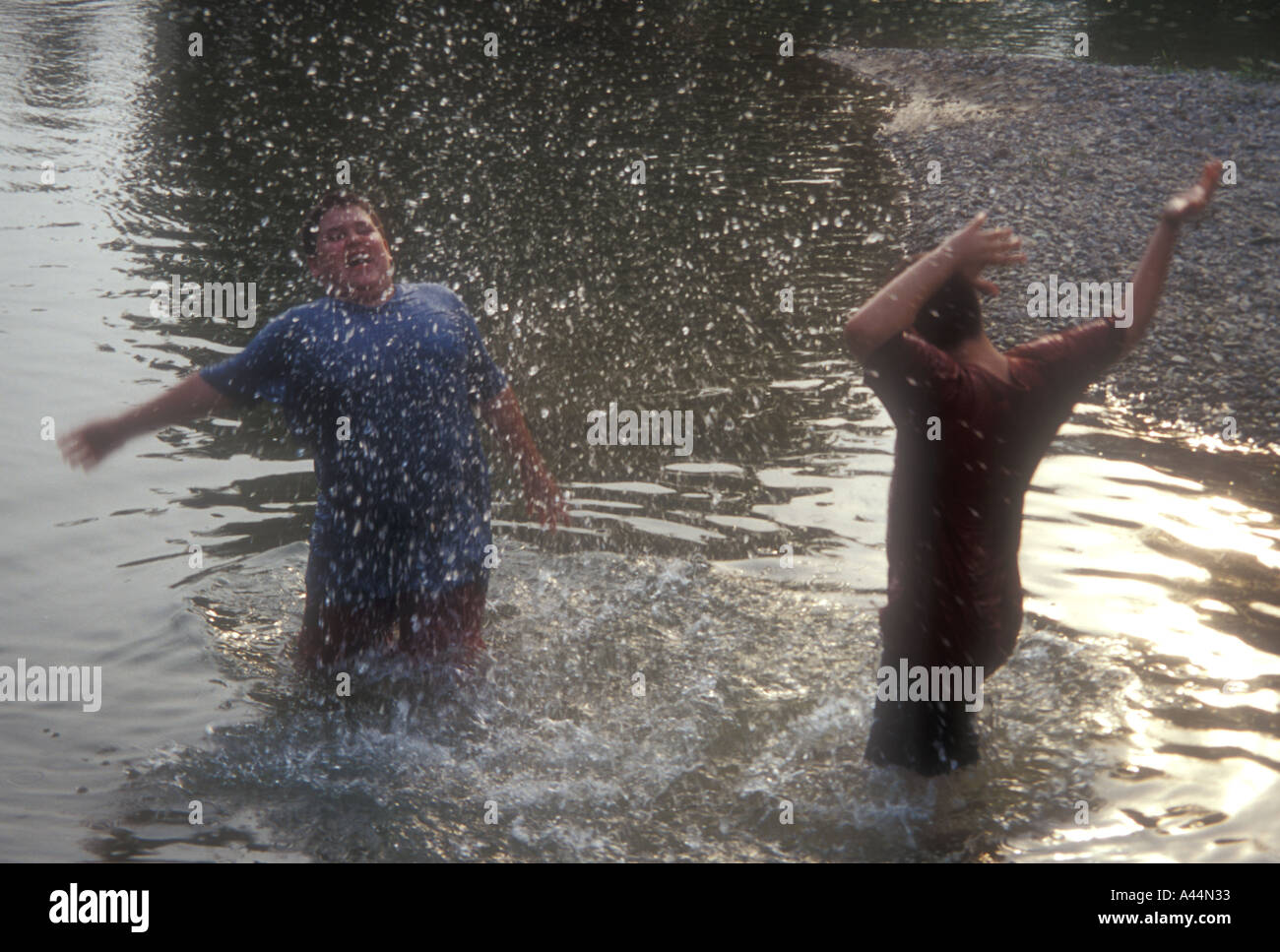 Ragazzi giocare nel fiume esuberante spontaneo disinibito energetico Foto Stock