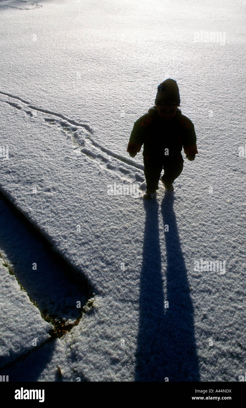 Il profilarsi la figura di un ragazzino a piedi attraverso la neve. Foto Stock