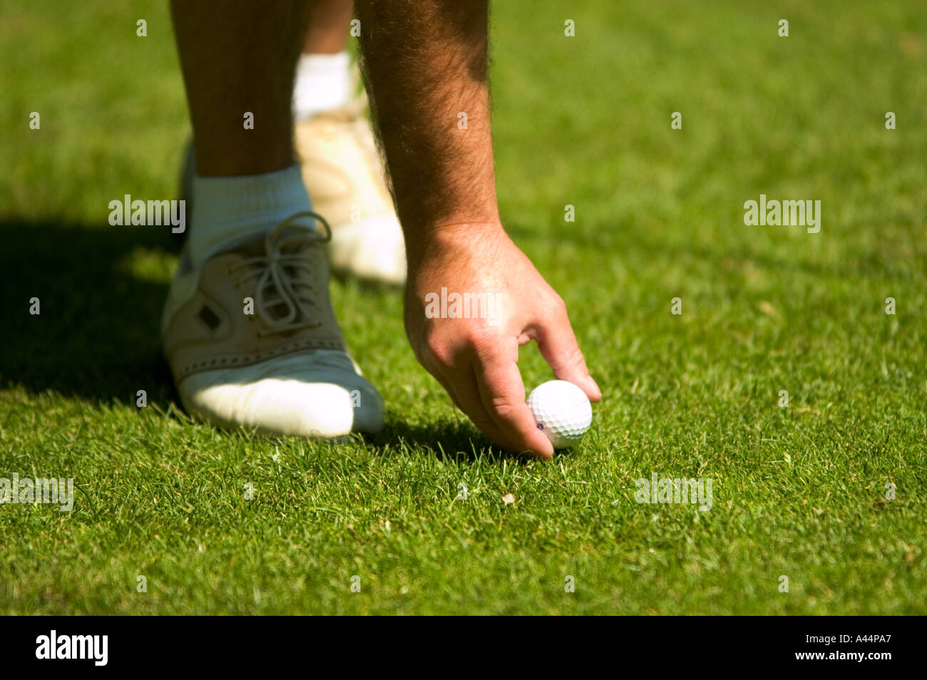 Giocatore di golf tees fino una pallina da golf Foto Stock