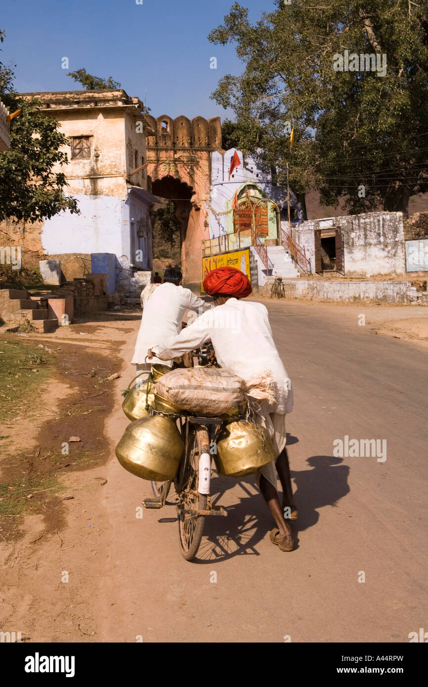 India Rajasthan Bundi milkmen spingendo il loro carico le biciclette attraverso la porta Vecchia a Segar Jait Lago Foto Stock