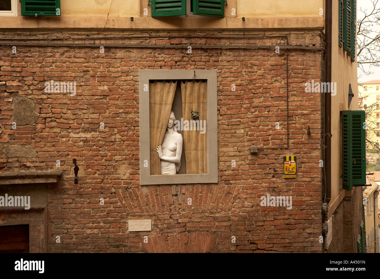 Statua di nudo di donna guardando fuori da una finestra nei vicoli di Siena  Foto stock - Alamy