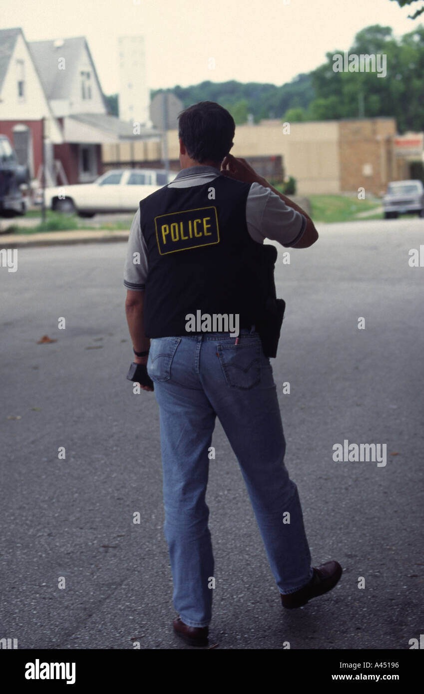 Plainclothes sergente di polizia con tenuta in mano radio. Kansas City, MO, il dipartimento di polizia pista Squad. Foto Stock