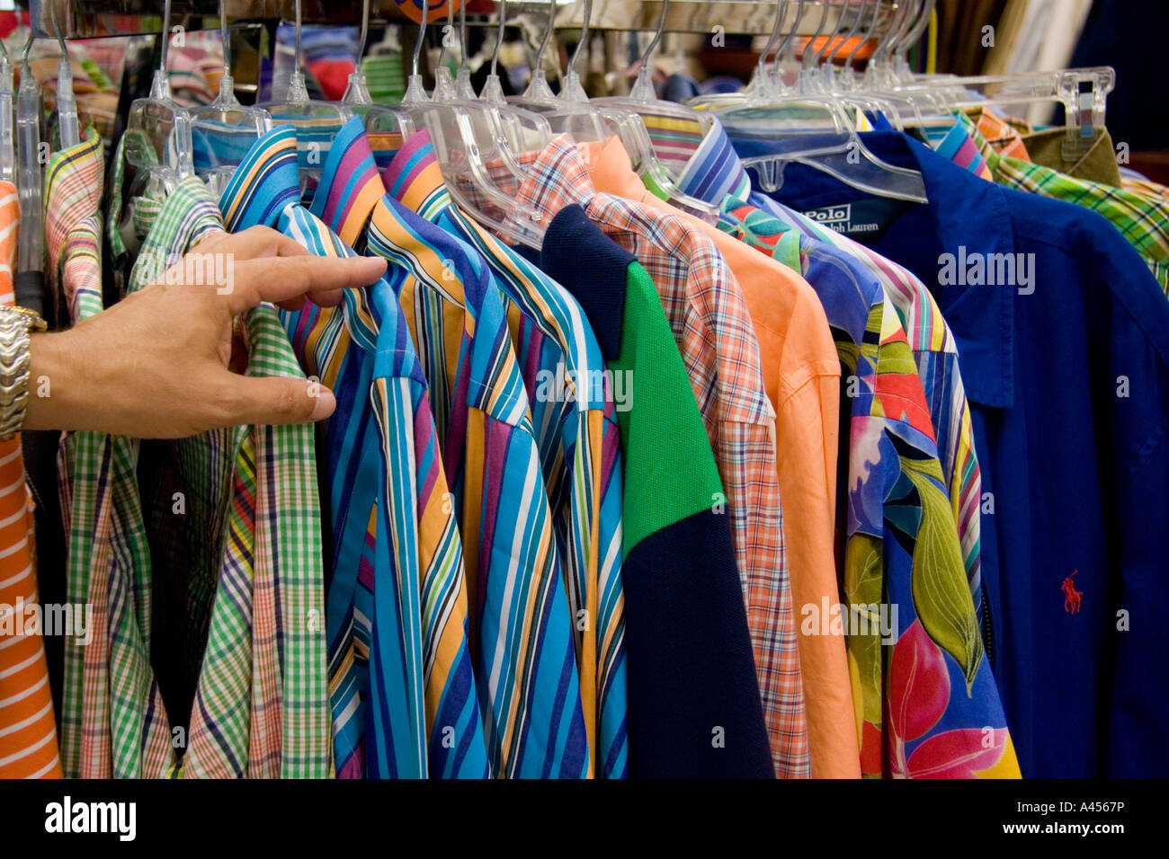 Uomo di cernita a mano a maniche lunghe camicie colorate, appendere il Department Store in rack Foto Stock