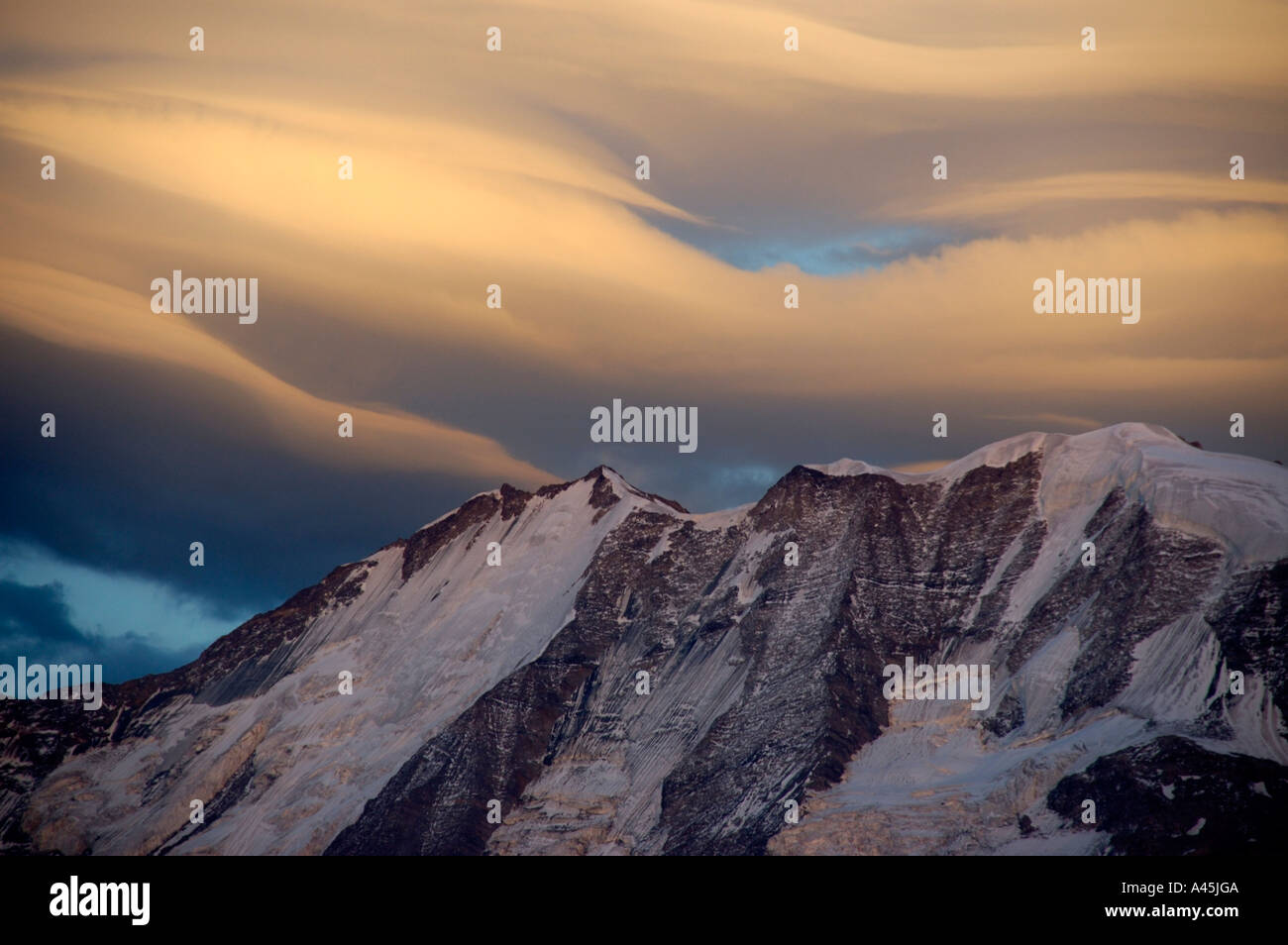 Veli di nuvole di foehn al di sopra di Mt. Blanc montagna alpenglow in Alta Savoia in Francia Foto Stock