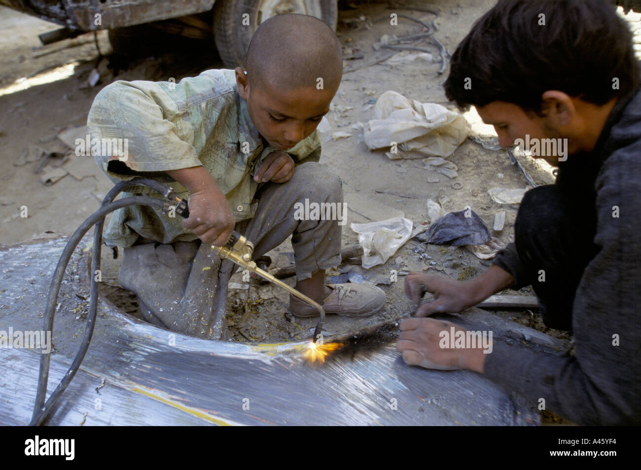 I bambini punto di saldatura un motore a Kabul in Afghanistan Foto Stock