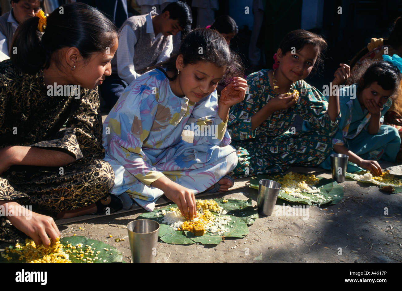 INDIA Asia Meridionale Himachal Pradesh Kulu ragazze mangiare da foglie di banano con le loro mani a pasto durante il matrimonio di paese Foto Stock