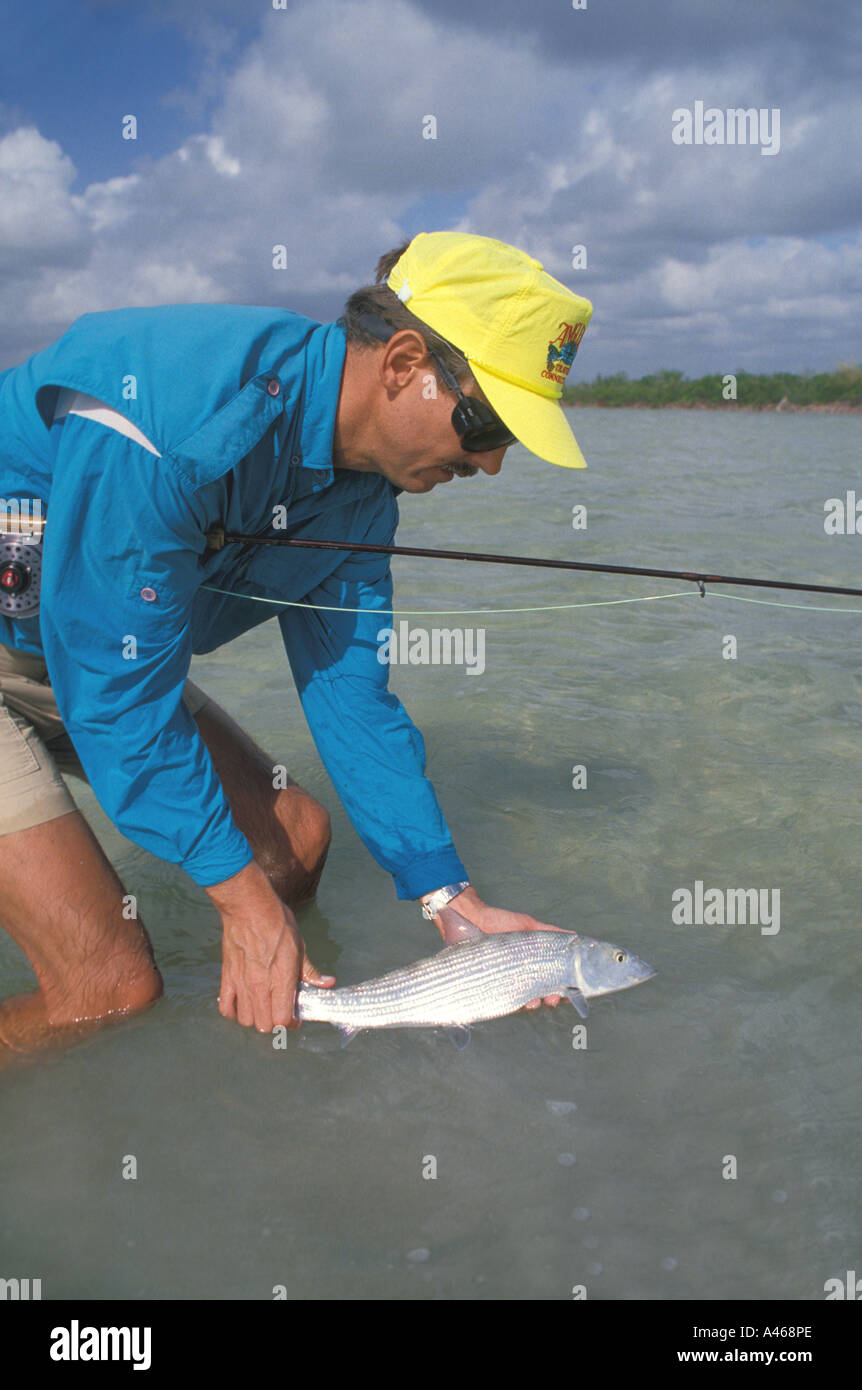 Acqua di sale la pesca pescatore rilasciando bonefish Foto Stock