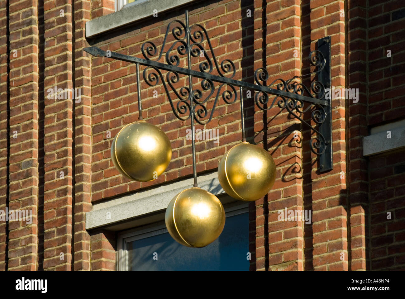 Negozio di pegni vicino a un tradizionale segno commerciale di tre palle d'oro sopra i negozi Pawnbroker, supportato da staffa di ferro ornamentale Inghilterra Regno Unito Foto Stock