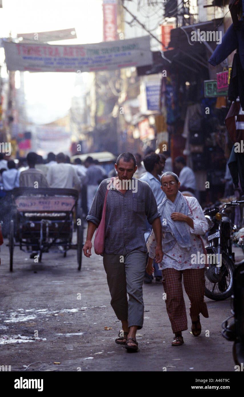 Viaggiatori occidentali a piedi attraverso la Pahar Ganj area di New Delhi India Foto Stock