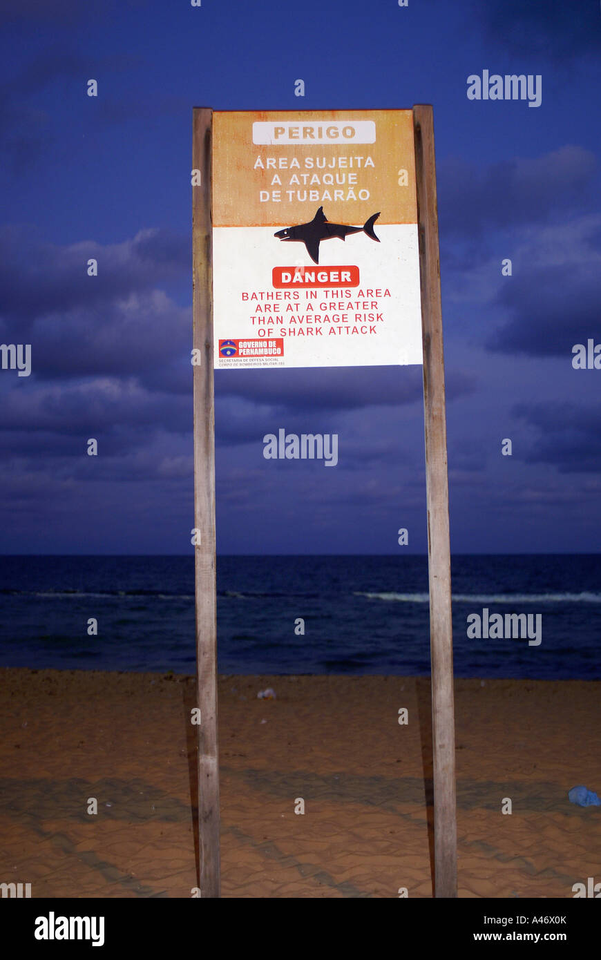 Segno bordo: 'Drabbia. I bagnanti in questa zona sono a un maggiore rischio medio di squalo attacca', Recife, Brasile Foto Stock