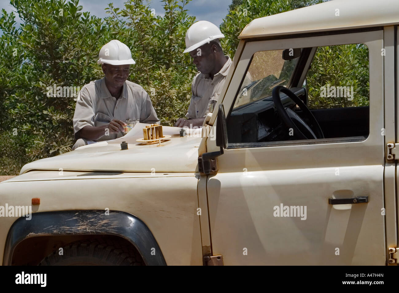 African manager ambientali discutendo tree programma di reimpianto, superficie miniera d'oro pit, Ghana, Africa occidentale Foto Stock
