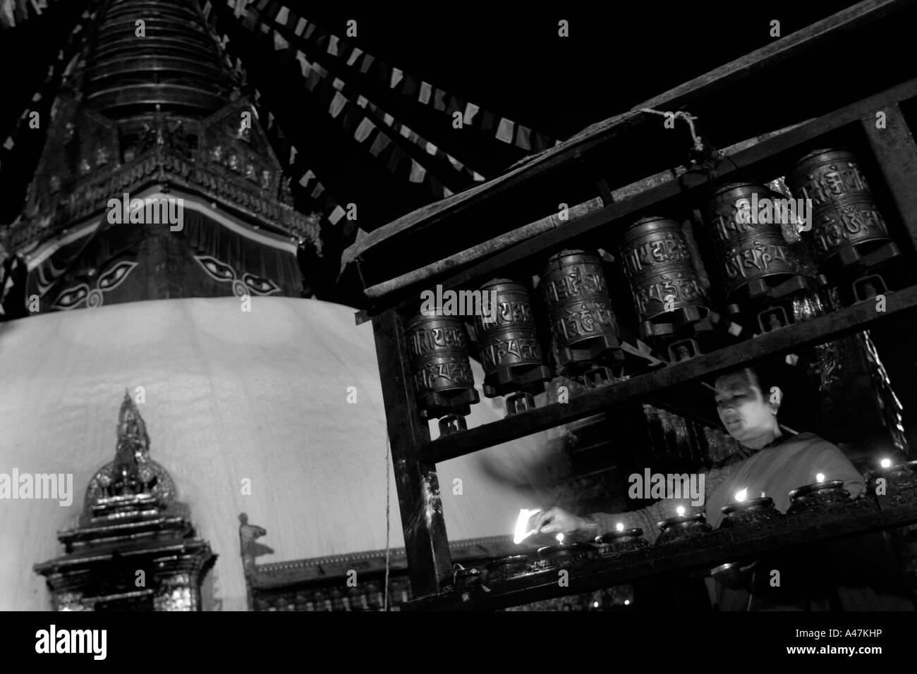 Un buddista tibetano luce donna candele al Swayambhunath Stupa di Kathmandu in Nepal Foto Stock