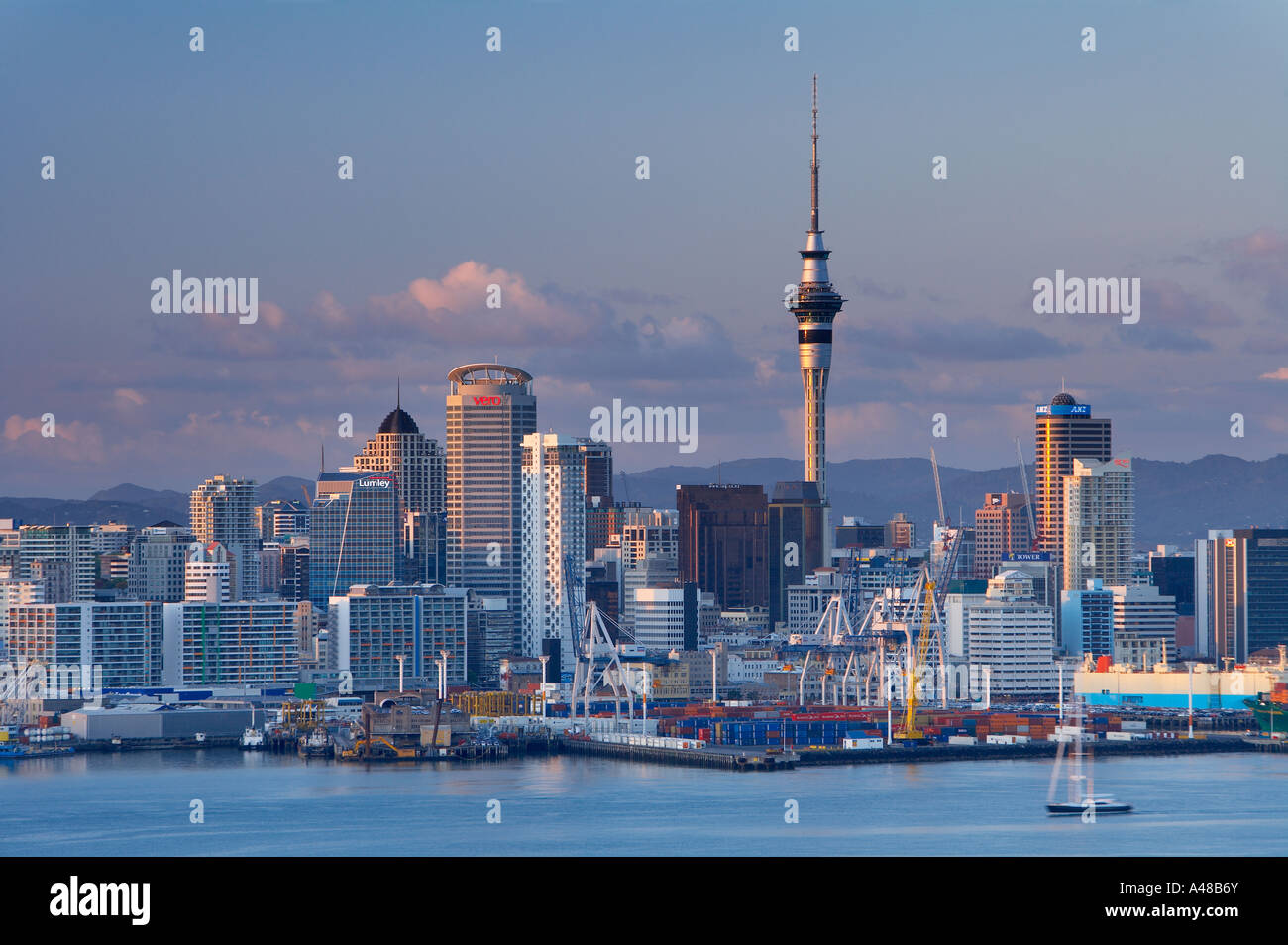 Il centro della città con la Skytower waterfront docks con uno yacht all'alba Auckland Nuova Zelanda NR Foto Stock