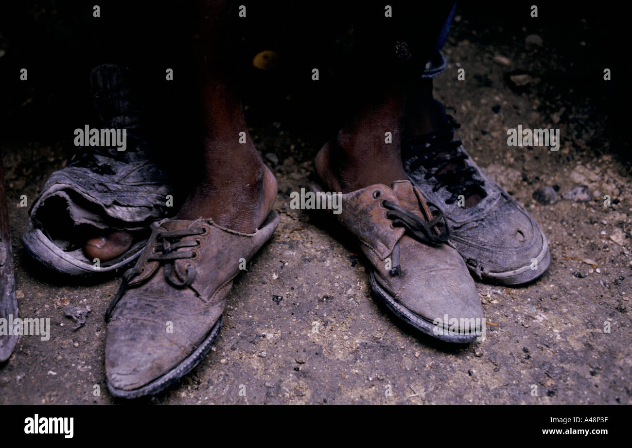 Impoverito i bambini in una delle baraccopoli in Haiti indossando usurati scarpe Foto Stock