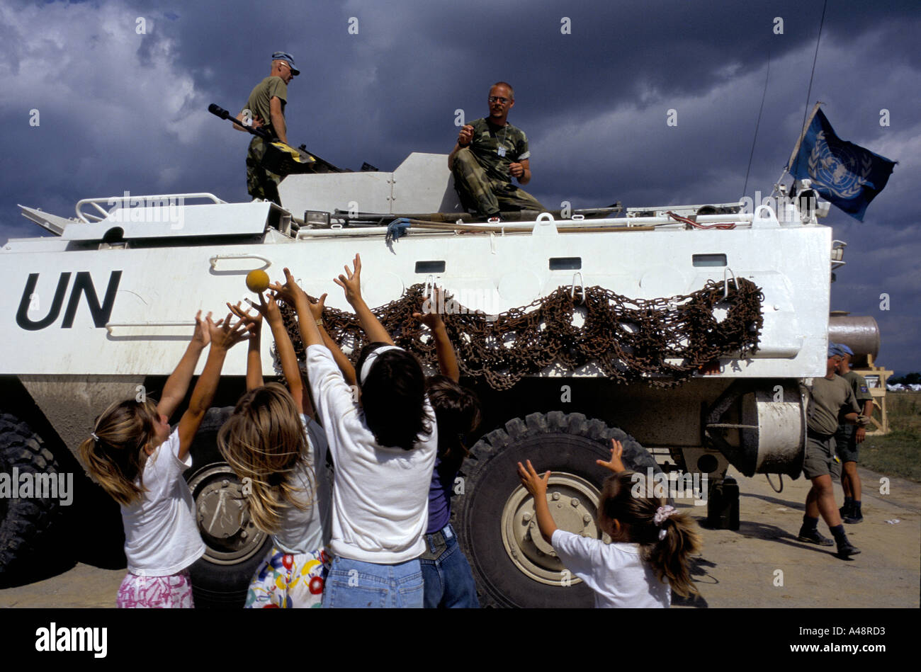 I bambini rifugiati da srebrenica giocare a palla con i soldati delle Nazioni Unite di tuzla airbase Foto Stock