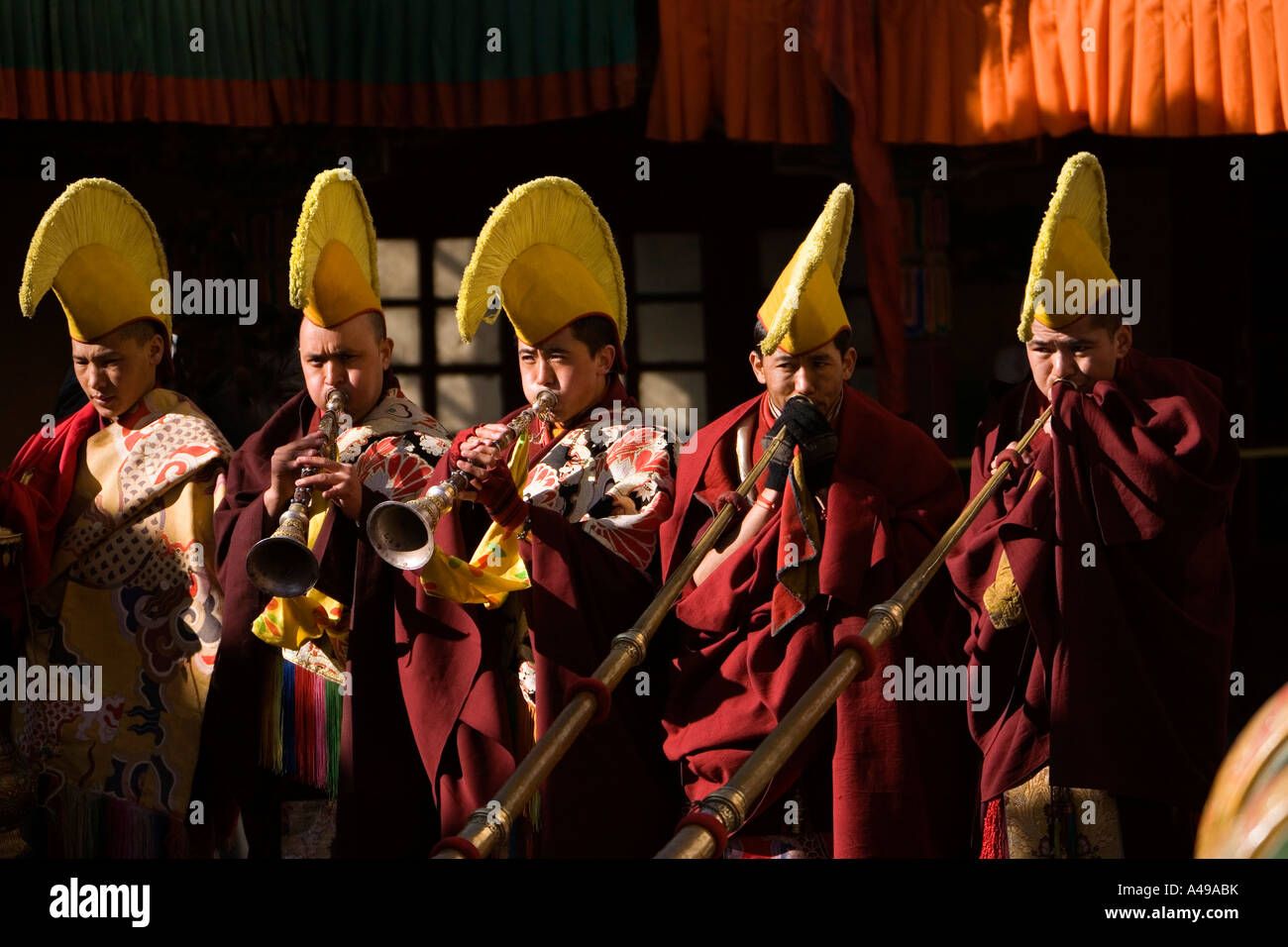 India Ladakh Leh Valle Gompa Spitok festival cappello giallo monaci soffia lungo le corna Foto Stock