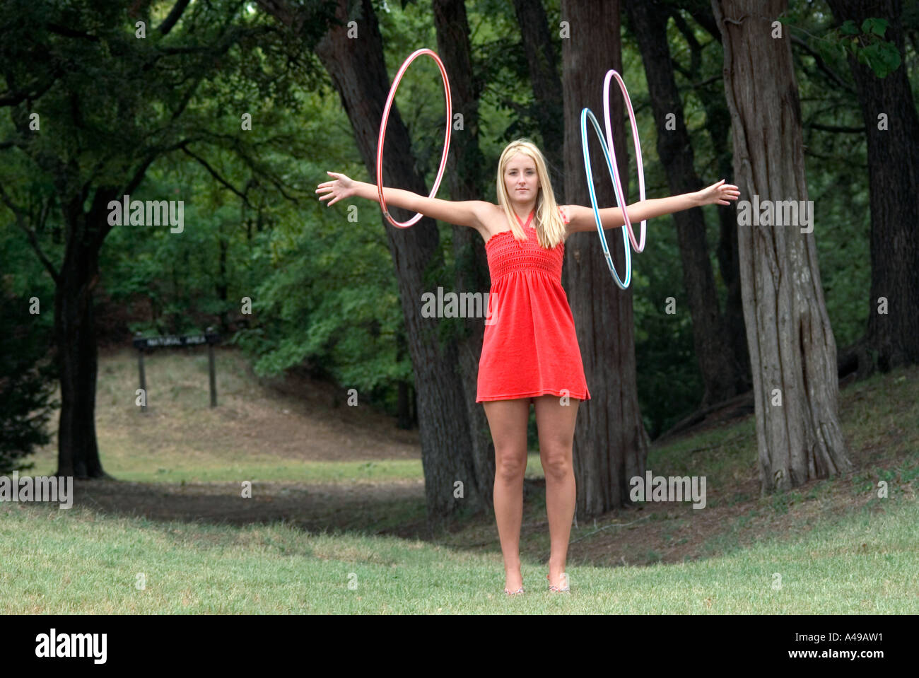 Ragazza fa roteare hoola hoops su bracci Foto Stock