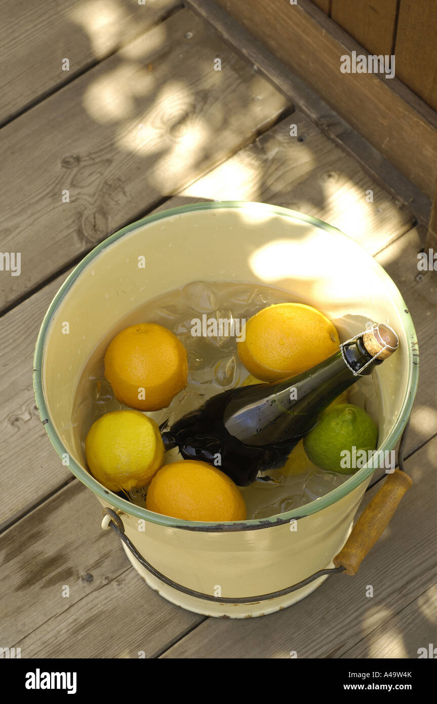 Elevato angolo di visione delle arance e una bottiglia di vino in una benna Foto Stock