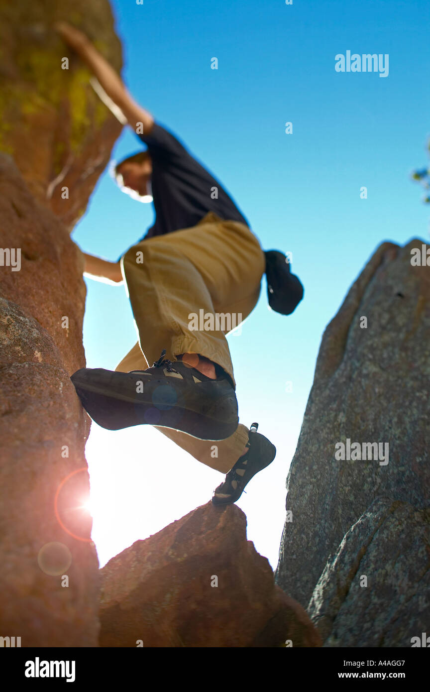 Sun flares al di sotto del basamento dell'uomo bouldering in Boulder Colorado Foto Stock