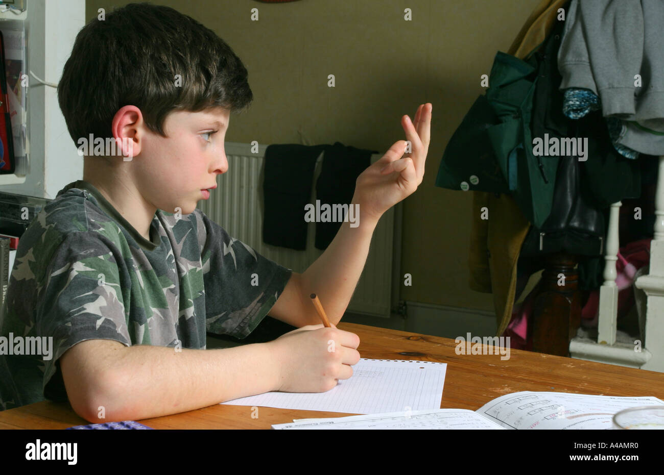 Un bambino di otto anni fa la sua matematica compiti a casa, febbraio 2006. Foto Stock