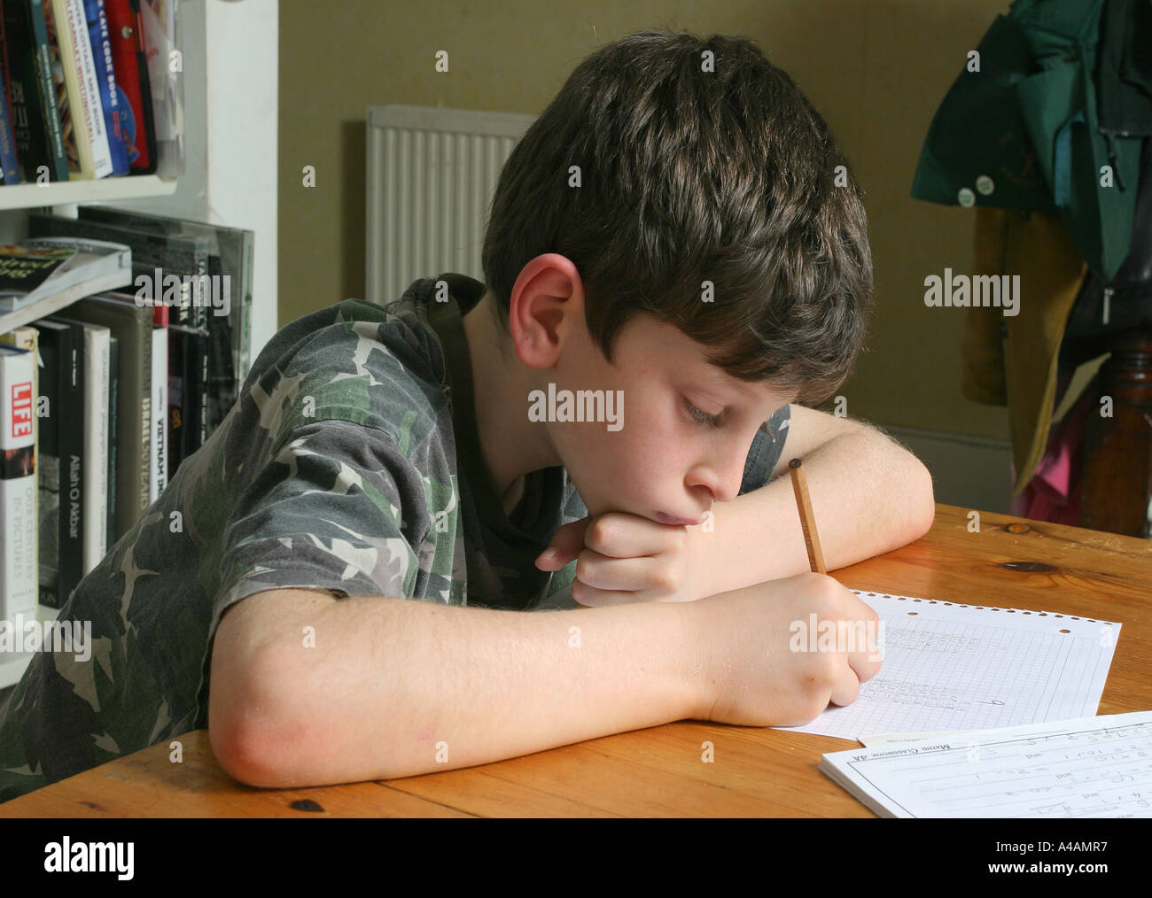 Un bambino di otto anni fa la sua matematica compiti a casa, febbraio 2006. Foto Stock