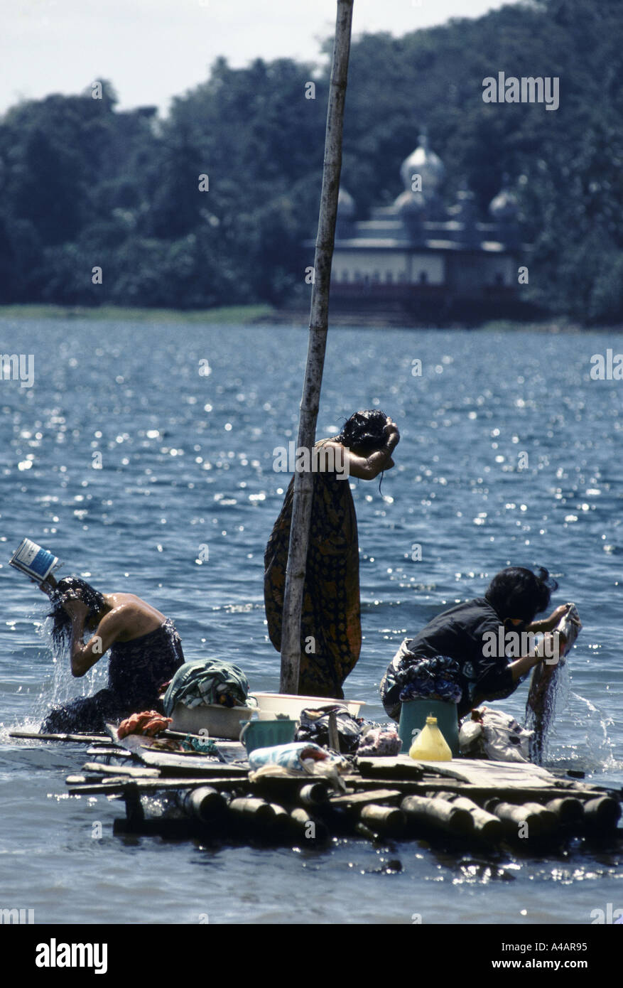 Pilippines : donne sulla piccola zattera di legno si bagnano nelle acque del lago Lanao, Marawi, isola di Mindanao, Feb 1991 Foto Stock