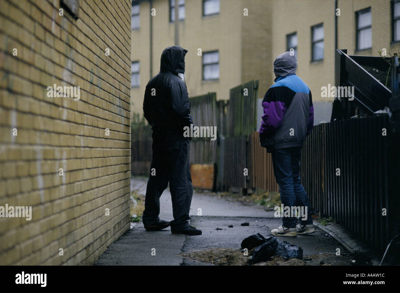 I trafficanti di droga parlando su strada in una corsa verso il basso la parte di Moss Side, Manchester, Inghilterra Foto Stock