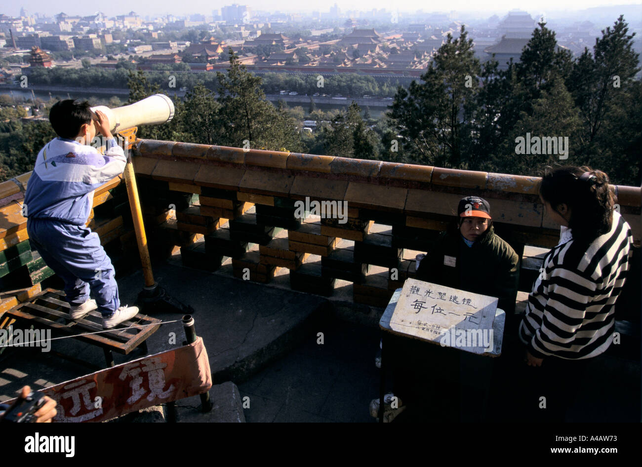 Pechino, Cina 1997: un bambino vedute della città proibita attraverso un telescopio da Jingshan Hill a nord Foto Stock