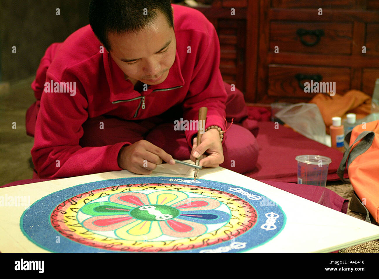 Monaco tibetano lavorando su un mandala di sabbia Foto Stock