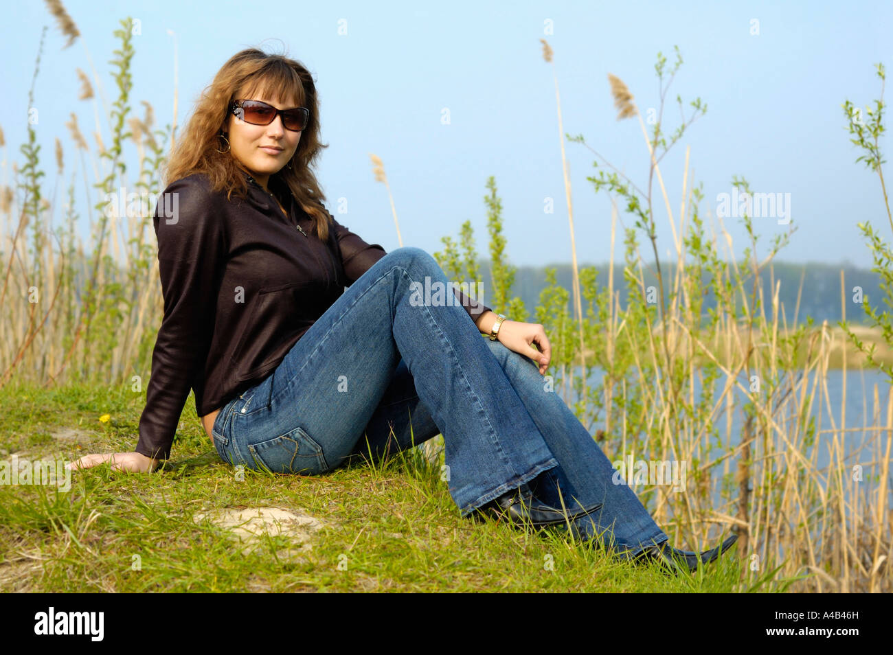 Giovane donna su una riva del lago Foto Stock