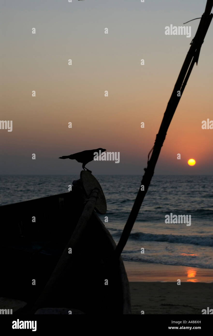 Immagine di stock di Benaulim Beach in Goa in India al tramonto con barca da pesca di silhouette e flag Foto Stock Immagine di stock di Benaulim Beach in Goa in India al tramonto con barca da pesca di silhouette e flag Foto Stock
