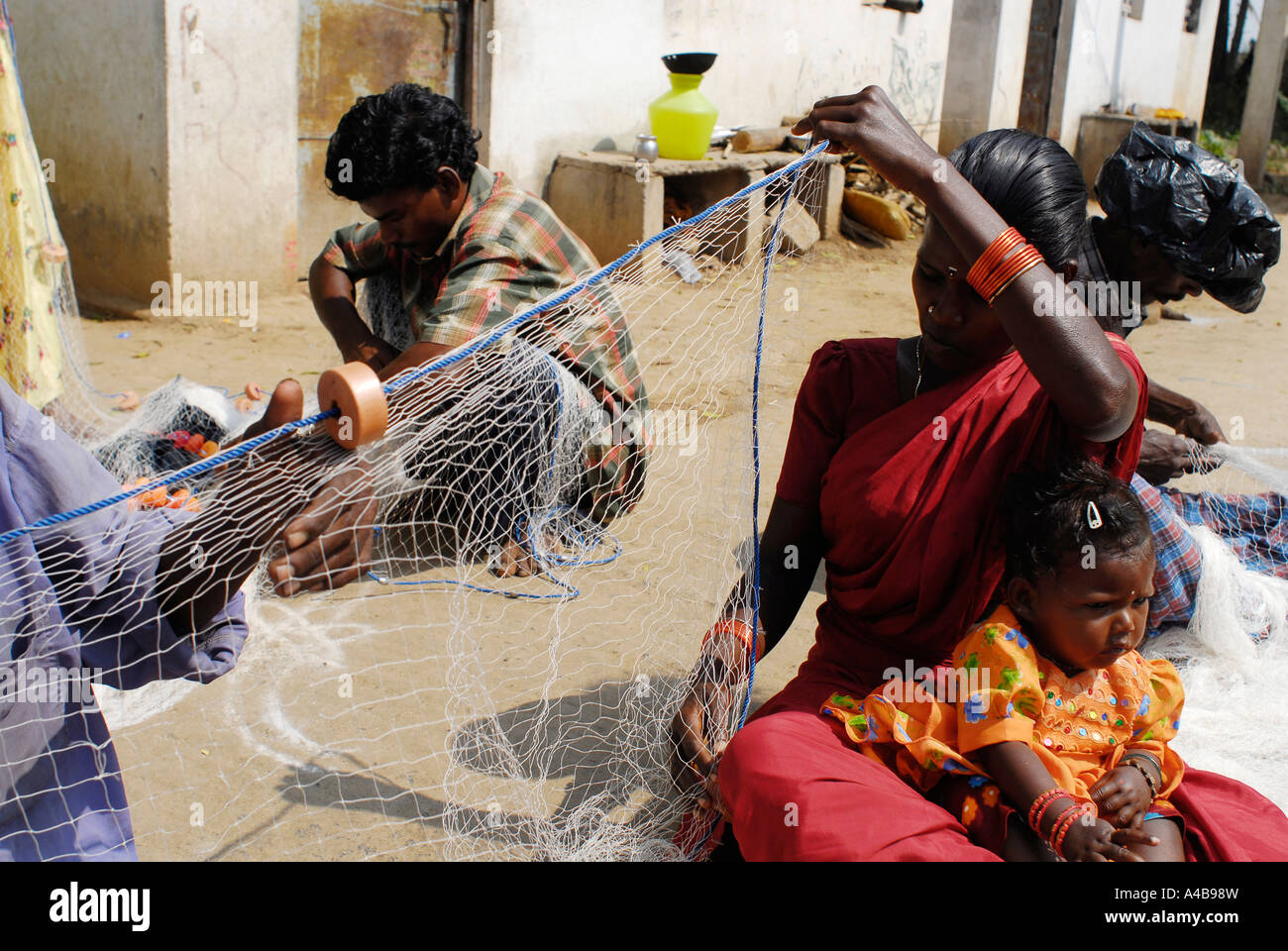 Immagine di stock di tribale indiano pescatore e la moglie di pescatori a riparare le reti da pesca vicino a Chennai Tamil Nadu India Foto Stock Immagine di stock di tribale indiano pescatore e la moglie di pescatori a riparare le reti da pesca vicino a Chennai Tamil Nadu India Foto Stock