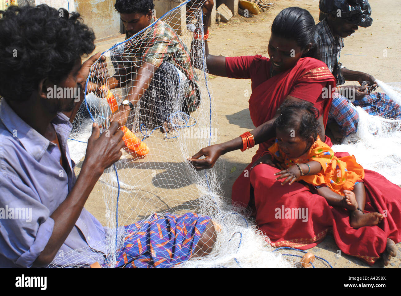 Immagine di stock di tribale indiano pescatore e la moglie di pescatori a riparare le reti da pesca vicino a Chennai Tamil Nadu India Foto Stock Immagine di stock di tribale indiano pescatore e la moglie di pescatori a riparare le reti da pesca vicino a Chennai Tamil Nadu India Foto Stock