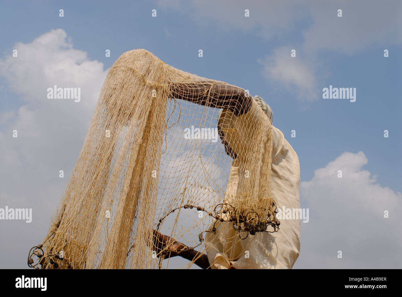 Immagine di stock di tribali dalit fisherman fusione il suo net indossando un turbante Foto Stock Immagine di stock di tribali dalit fisherman fusione il suo net indossando un turbante Foto Stock