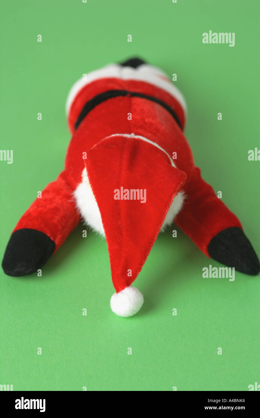 Giocattolo imbottito Santa Claus sdraiato sul pavimento verde Foto Stock