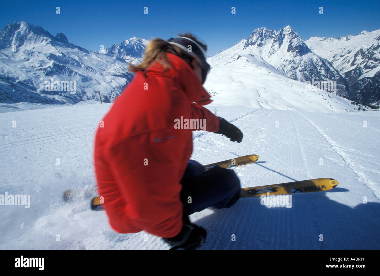 Sciatore maschio, con capelli lunghi, carving giù un preparato di fresco pista nelle Alpi francesi nei pressi di Chamonix Foto Stock