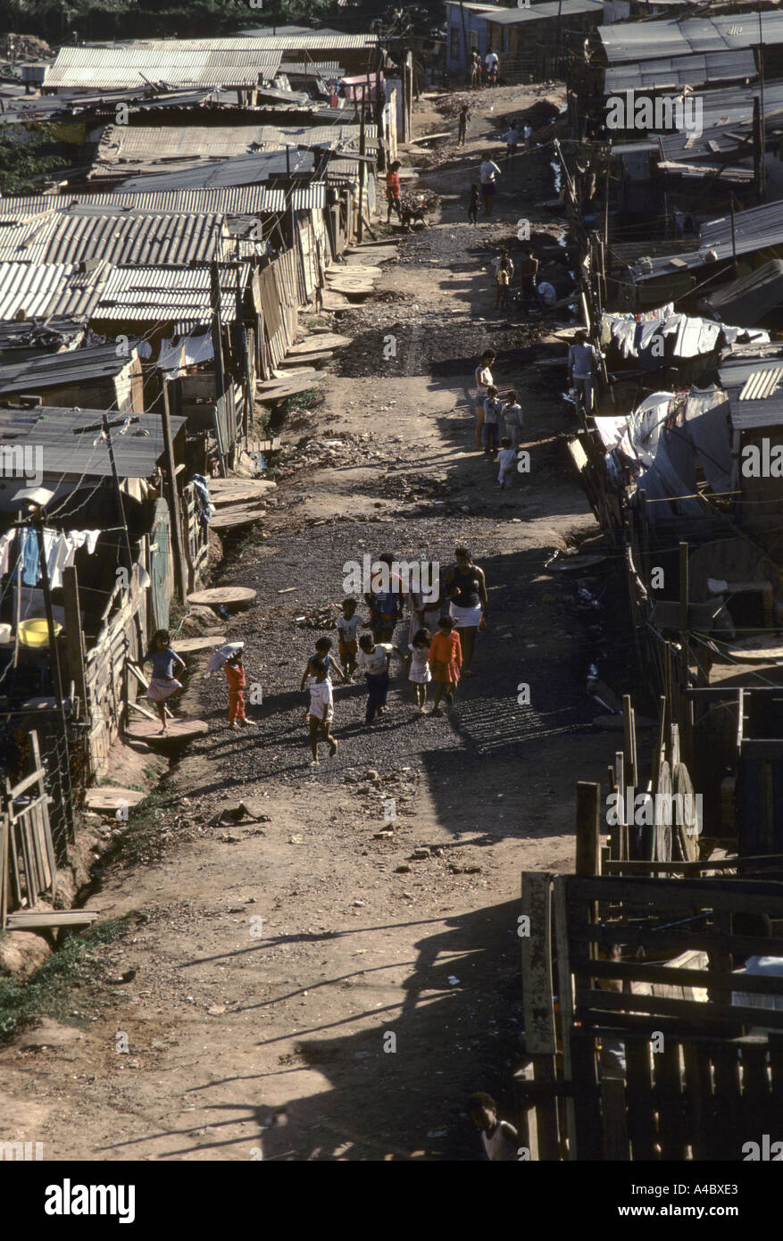 Residenti a piedi lungo il percorso tra baracche presso la Casa Verde invasione di terra di Sao Paulo in Brasile Foto Stock